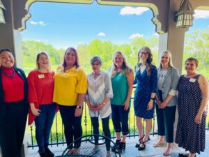 Stephanie (3rd from the left) with the other Sunflower Sisters dressed in Pride Flag colors surrounding Governor Laura Kelly, Cedarcrest (Governor’s Mansion), in Topeka, Kansas, 2021. Photo courtesy of Stephanie Byers.