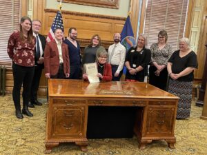 Stephanie (3rd from the right) and others in the Governor’s Ceremonial Office for the signing of Kansas First Proclamation for Transgender Day of Visibility at the Kansas Capitol, in Topeka, Kansas, 2022. Photo courtesy of Stephanie Byers.