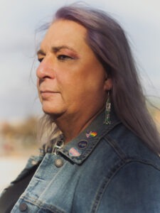 Close up side portrait of Stephanie with lavender hair in a jean jacket from a photo shoot for Southern Poverty Law Center’s 2022 Report. Topeka, Kansas, 2022. Photo courtesy of Stephanie Byers.