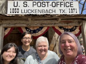 R-L: Smiling family photo of Stephanie Byers with her wife Lori Haas, and their two oldest grandchildren, Kenzie and Riley, at Luckenbach, Texas, 2024. Photo courtesy of Stephanie Byers.