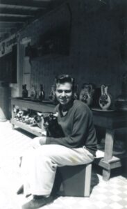 Gerald (age 19) smiling while sitting on a ledge and holding a ceramic bull during his first honeymoon in Tijuana, Mexico, 1952. Photo courtesy of Gerald Gerash.