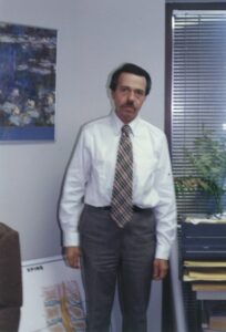 Gerald in a suit and tie standing in a law office in Denver, Colorado, 1982. Photo courtesy of Gerald Gerash. 