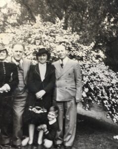 A family portrait of the Gerash family outside a family friends' house in New Jersey. L-R: The friends, Leah Gerash (Gerald's mother), Gerald Gerash (age 5, hugging his mother's leg), and Ben Gerash (Gerald's father). Gerald shares, 