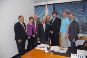 Gerald Gerash (at center, in a green zip-up jacket) and Congressman Henry Waxman (at center, in a suit and tie) meeting with local AIDS groups, West Los Angeles, California, 2008. Gerash met with two scientists and Michael Weinstein while lobbying to increase funding for research to cure HIV. Photo courtesy of Gerald Gerash.