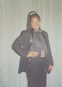 Betty posing in a black suit and kente cloth while attending the Junior Culinary Team competition at the American Culinary Federation’s National Culinary Convention, Washington, D.C., 1992. Photo courtesy of Betty Berrysmith.