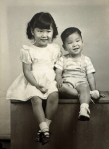 Greyscale photo of Marsha Aizumi (age 5?) and her younger brother. Cleveland, OH, 1951. Photo courtesy of Marsha Aizumi.