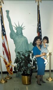 Marsha hugs and carries Aiden in front of a miniature Statue of Liberty on Aiden’s naturalization’s day. Los Angeles, CA, 1990. Photo courtesy of Marsha Aizumi.