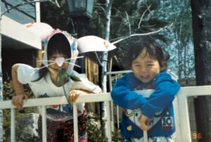 Easter sibling photo of Aiden (left) and Stefen Aizumi on a balcony in front of trees. Arcadia, CA, 1994. Photo courtesy of Marsha Aizumi.