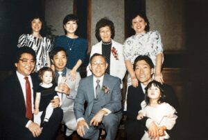 Smiling family group photo during Marsha Aizumi’s parent’s 40th anniversary party (before Aiden and Stefen). Marsha is in the blue dress, in the back row. Los Angeles, CA, 1986. Photo courtesy of Marsha Aizumi.