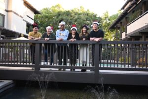 Matching Santa-hat Christmas family photo (L-R) Aiden, his partner Mary, father Tad, Marsha, Stephen’s partner Catherin, and brother Stefen. Pasadena, Los Angeles, CA, 2023. Photo courtesy of Marsha Aizumi.