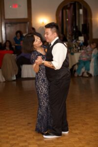 Marsha smiles affectionately at Aiden as they dance in front of a crowd during Aiden and Mary’s wedding reception. Long Beach, CA, 2013. Photo courtesy of Marsha Aizumi.