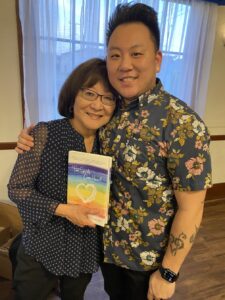 Marsha and Aiden hug while holding up their book “Two Spirits, One Heart.” Montebello, CA, 2022. Photo courtesy of Marsha Aizumi.