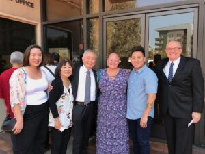 Smiling group photo of (L-R) Marsha Aizumi, George Takei, Mary (Aiden’s partner), Aiden Azumi, and Brad Takei; Marsha shares that George and Brad are wonderful supports of their work. Los Angeles, circa 2016. Photo courtesy of Marsha Aizumi.