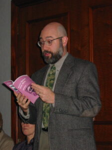 Jeff Mann in a grey suit reading at the 2003 AWP (Association of  Writers & Writing Programs Conference. Baltimore, Maryland, February 2003. Photo courtesy of Jeff Mann. 