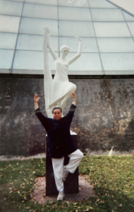 Harriet Miller poses playfully with a dancer-statue  in Guadalajara, Mexico, 2001. Photo Courtesy of Harriet Miller and Monica Wehrle.