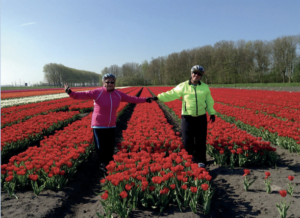 Harriet Miller and Monica Wehrle on a Netherlands Bike and Barge Tour with family friends. Amidst a field of vivid, red flowers in the Netherlands, 2013. Photo Courtesy of Harriet Miller and Monica Wehrle.