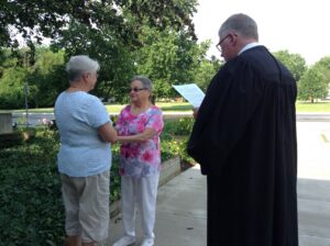 Photo from Monica Wehrle and Harriet Miller’s marriage ceremony with Judge Mike 
Rush (R). In  Fort Wayne, Indiana, 2014. Photo Courtesy of Harriet Miller and Monica Wehrle.