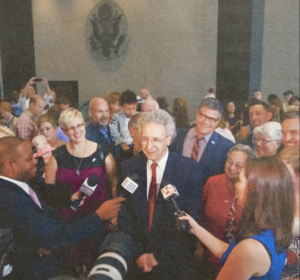 Monica Wehrle and Harriet Miller with the ACLU Indiana Marriage Equality plaintiffs, 
speaking with Attorney Ken Faulk in a sea of reporters. In Chicago, Illinois, 2014. Photo Courtesy of Harriet Miller and Monica Wehrle.