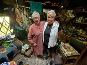 Harriet Miller smiles with her sister Rivkah in an eclectic cabin on Orcas Island, Washington, 2022. Photo Courtesy of Harriet Miller and Monica Wehrle.