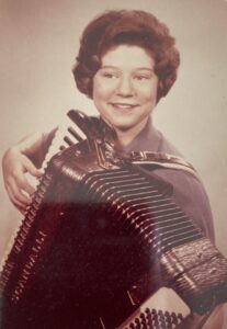 Monica Wehrle smiles coyly with a short haircut while playing the accordion. Fort Wayne, Indiana, 1964. Photo Courtesy of Harriet Miller and Monica Wehrle.